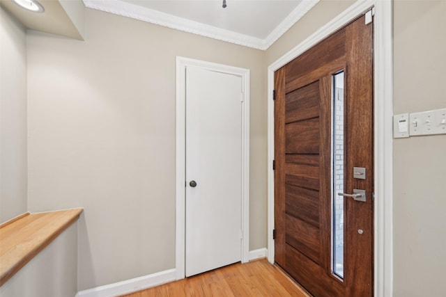 foyer entrance featuring crown molding and light hardwood / wood-style floors