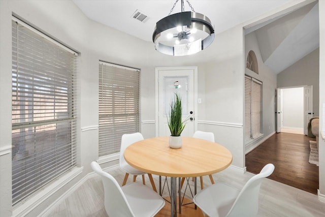 dining area with vaulted ceiling and a chandelier