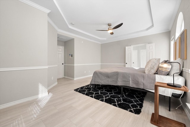 bedroom with crown molding, ceiling fan, and a raised ceiling