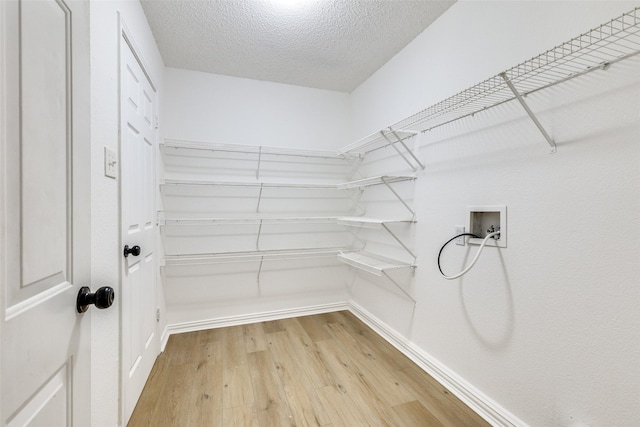 walk in closet with hardwood / wood-style floors