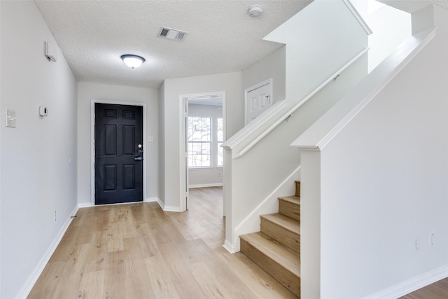 entrance foyer with a textured ceiling and light wood-type flooring