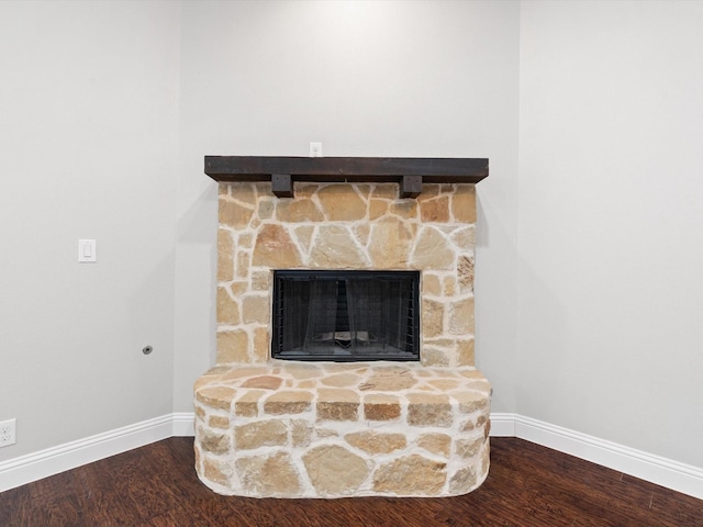 room details with a fireplace, wood finished floors, and baseboards