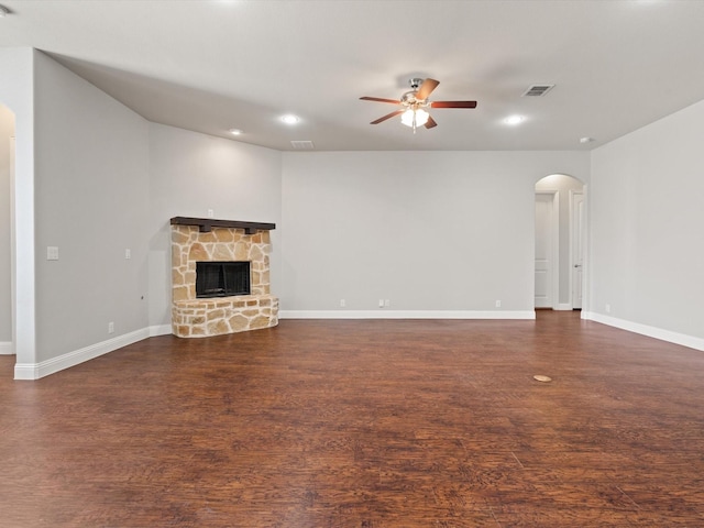 unfurnished living room featuring a stone fireplace and ceiling fan