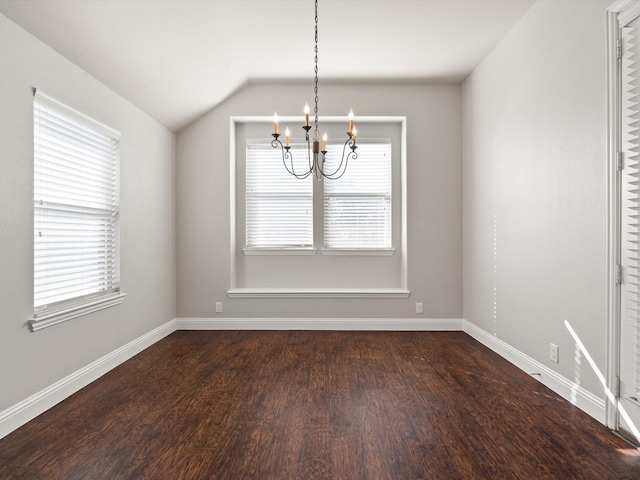 interior space featuring dark wood-style floors, lofted ceiling, a notable chandelier, and plenty of natural light