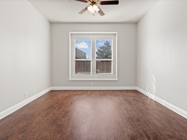 empty room featuring baseboards, dark wood finished floors, and a ceiling fan