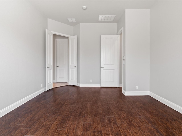 unfurnished bedroom with wood finished floors, visible vents, and baseboards