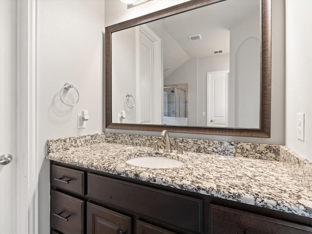 full bath with visible vents, vaulted ceiling, vanity, and a shower stall