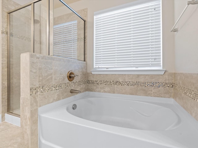 bathroom featuring a garden tub and a shower stall