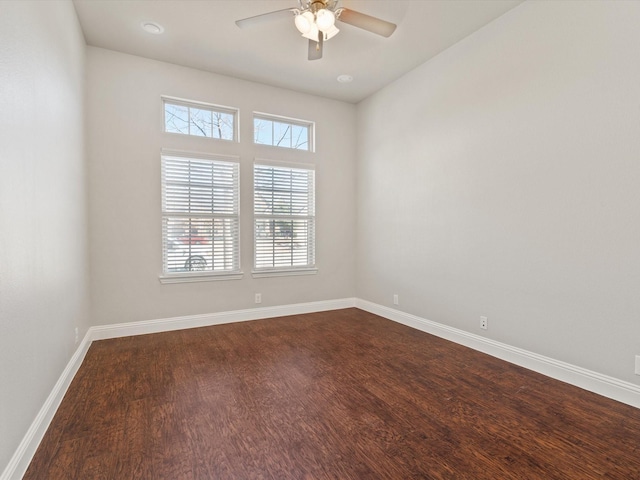 unfurnished room featuring dark wood-type flooring, baseboards, and a ceiling fan