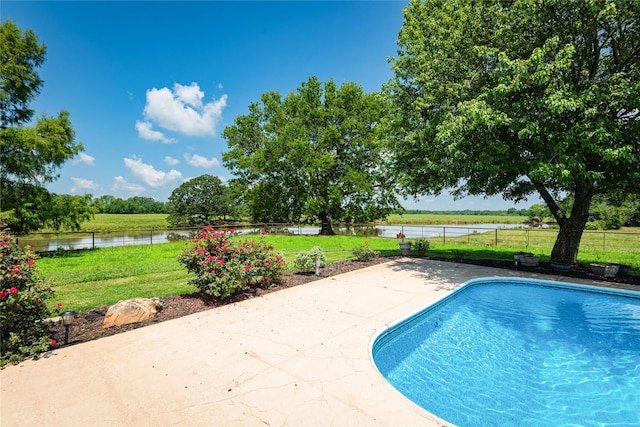 view of pool with a water view, a yard, and a patio