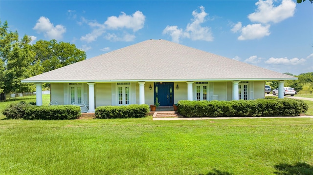 farmhouse-style home featuring french doors, covered porch, a front yard, and roof with shingles
