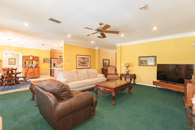 living room featuring dark colored carpet, ornamental molding, and ceiling fan with notable chandelier