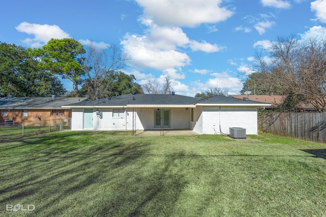 back of property featuring a lawn and central air condition unit