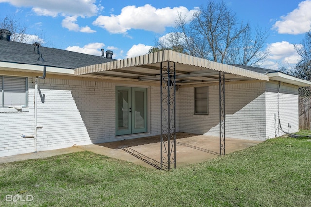 rear view of property featuring a yard, a patio area, and french doors