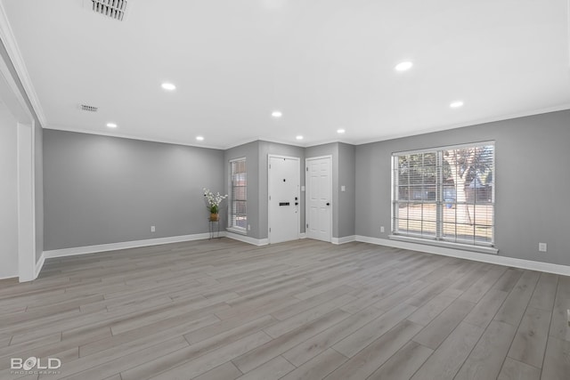 unfurnished living room featuring ornamental molding and light hardwood / wood-style floors