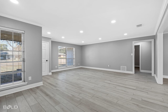 empty room featuring ornamental molding and light hardwood / wood-style flooring