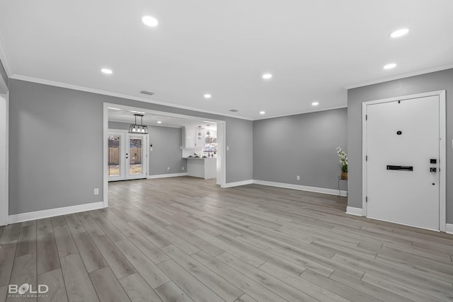 unfurnished living room featuring ornamental molding and light hardwood / wood-style floors