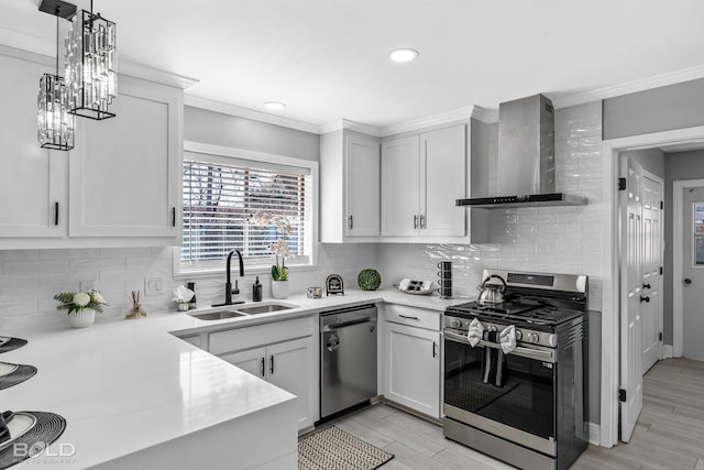 kitchen with tasteful backsplash, sink, white cabinets, stainless steel appliances, and wall chimney range hood