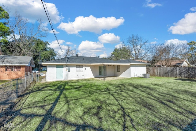 back of house with cooling unit and a lawn