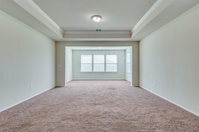 empty room featuring light carpet, crown molding, and a raised ceiling