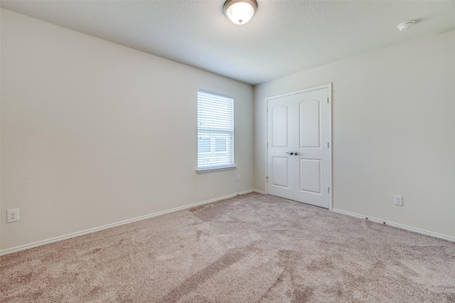 unfurnished room with light carpet