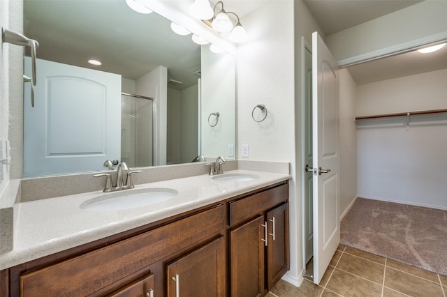 bathroom featuring a shower with door, vanity, and tile patterned floors