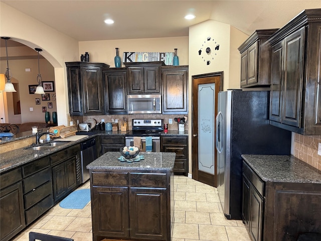 kitchen with light tile patterned flooring, a kitchen island, appliances with stainless steel finishes, backsplash, and kitchen peninsula