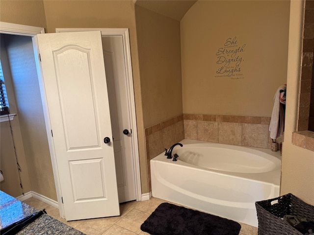 bathroom with a tub to relax in and tile patterned floors