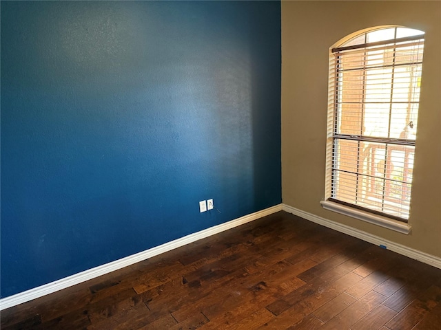 unfurnished room with a healthy amount of sunlight and dark hardwood / wood-style flooring