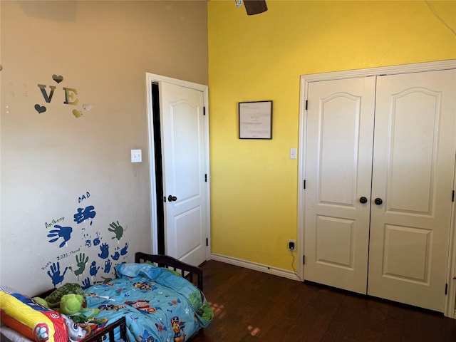 bedroom with dark hardwood / wood-style flooring, a closet, and ceiling fan