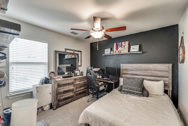 bedroom featuring ceiling fan, light carpet, and multiple windows