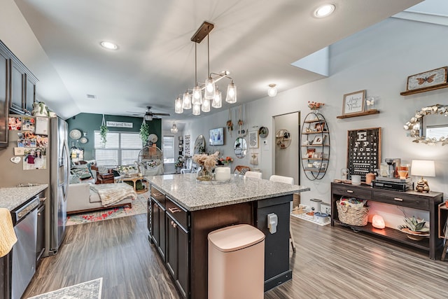 kitchen with hanging light fixtures, dark hardwood / wood-style floors, a center island, and appliances with stainless steel finishes