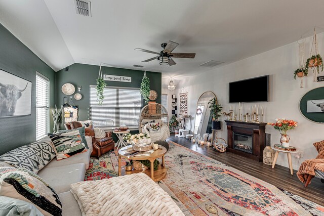living room with a ceiling fan, visible vents, wood finished floors, and lofted ceiling