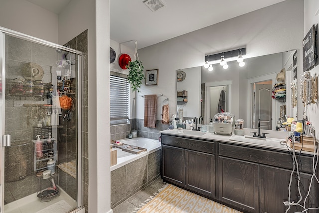 bathroom featuring plus walk in shower, vanity, and tile patterned floors