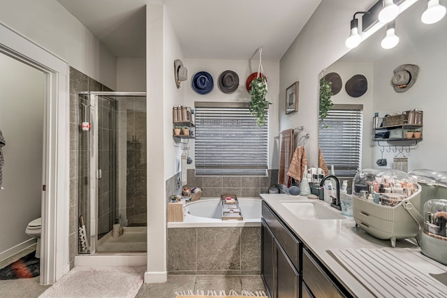 full bathroom featuring tile patterned flooring, shower with separate bathtub, vanity, and toilet