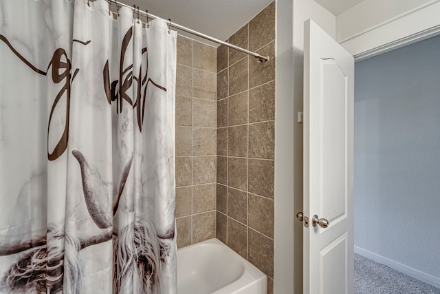 bathroom featuring baseboards and shower / bathtub combination with curtain