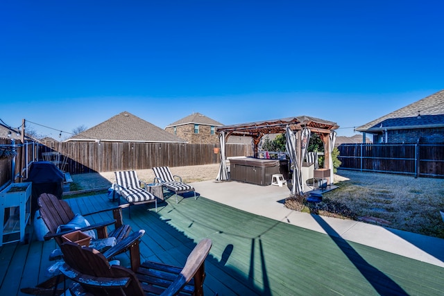 wooden terrace with a fenced backyard and a hot tub