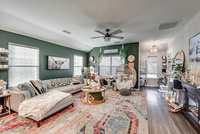 living area with a ceiling fan, visible vents, wood finished floors, and lofted ceiling