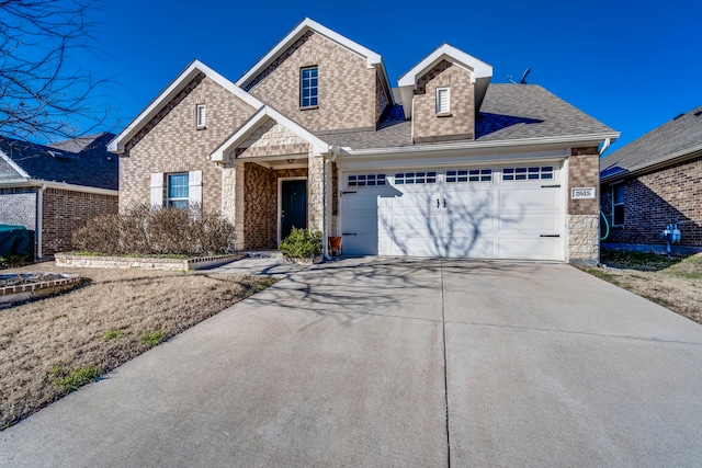 traditional-style home featuring stone siding, roof with shingles, brick siding, concrete driveway, and an attached garage