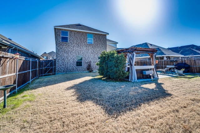 rear view of house featuring a fenced backyard, a gazebo, a yard, and a patio area
