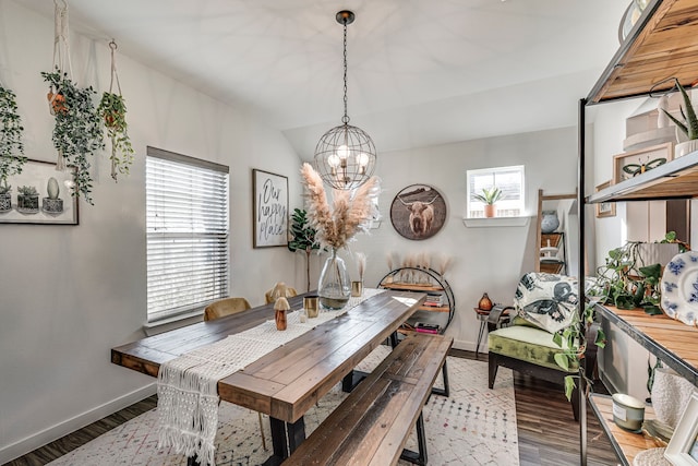 dining room featuring an inviting chandelier, baseboards, wood finished floors, and a wealth of natural light