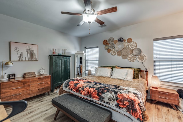 bedroom with multiple windows, ceiling fan, and light wood-type flooring