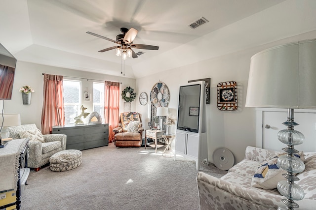living room with visible vents, carpet flooring, a raised ceiling, and a ceiling fan
