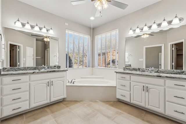 bathroom with tile patterned flooring, vanity, a bath, and ceiling fan