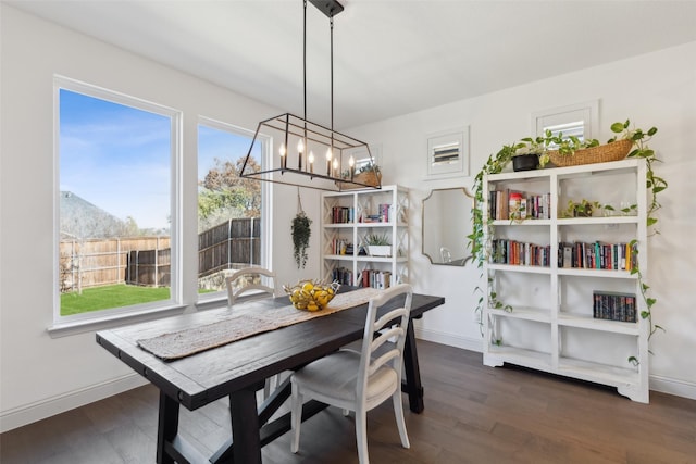 dining area featuring dark wood-type flooring and a chandelier