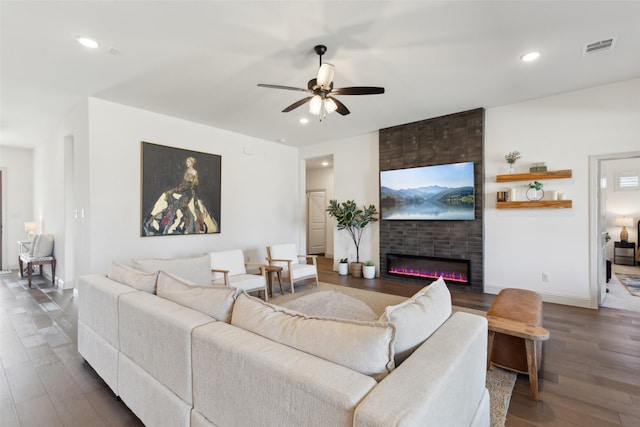 living room with ceiling fan, a large fireplace, visible vents, recessed lighting, and wood finished floors