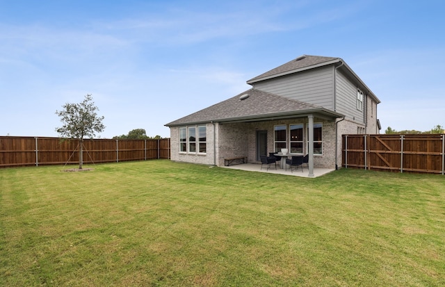 rear view of house with a patio and a lawn