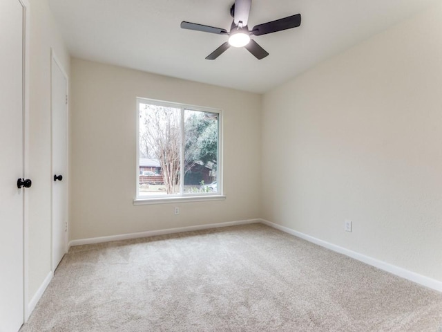 carpeted spare room featuring ceiling fan