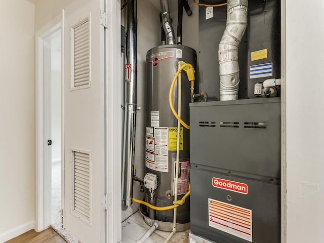 utility room featuring heating unit and gas water heater