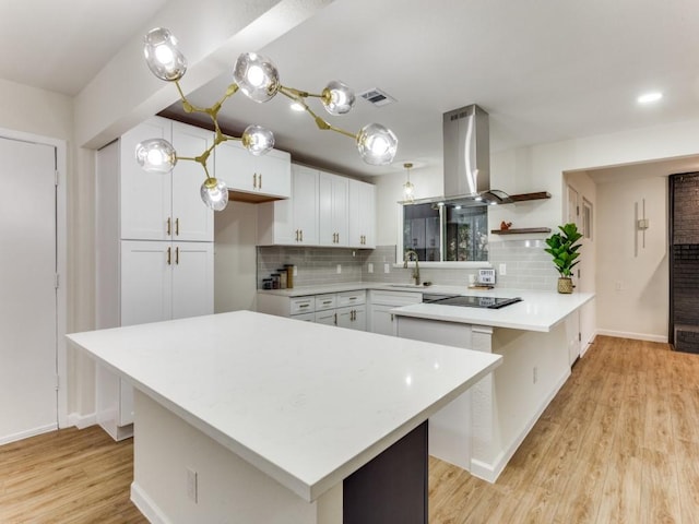 kitchen featuring white cabinetry, backsplash, sink, and a kitchen island